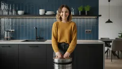 Usměvavá žena v moderní kuchyni drží sud na pivo, domácí prostředí, gastronomie.